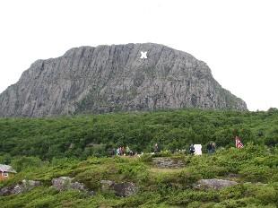<p>Risneshaugane med Risnesnipa i bakgrunnen. Risnesnipa er ein del av fjellmassivet som g&aring;r under namnet Lihesten. "Hav&oslash;rn" flaug inn i fjellveggen. Biletet vart teke 14. juni 2008 d&aring; minnesmerket om ulukka vart avduka.r. Krossen syner kvar flyet traff fjellet.</p>