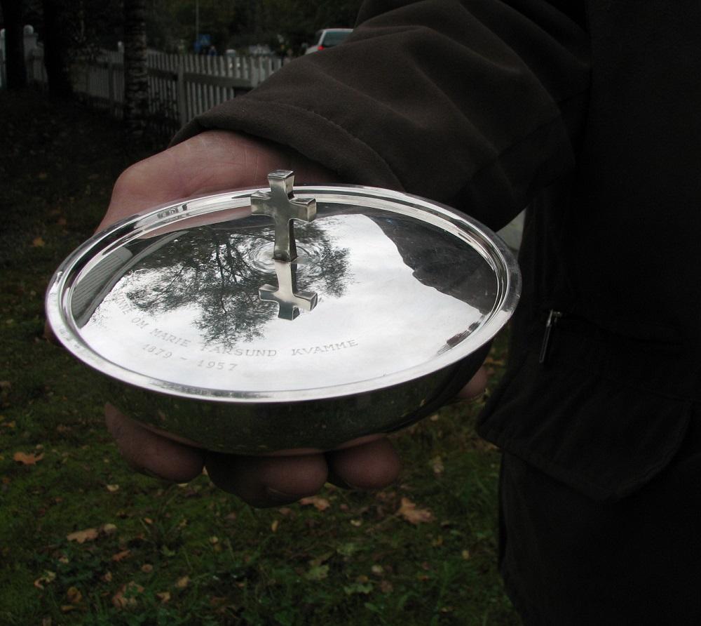 Sølvskåla har ein diameter på ca 16 cm og er ca 4 cm høg. Krossen på loket er omlag 2,5 cm høg. Skåla er laga av gullsmed David Andersen i Oslo.



