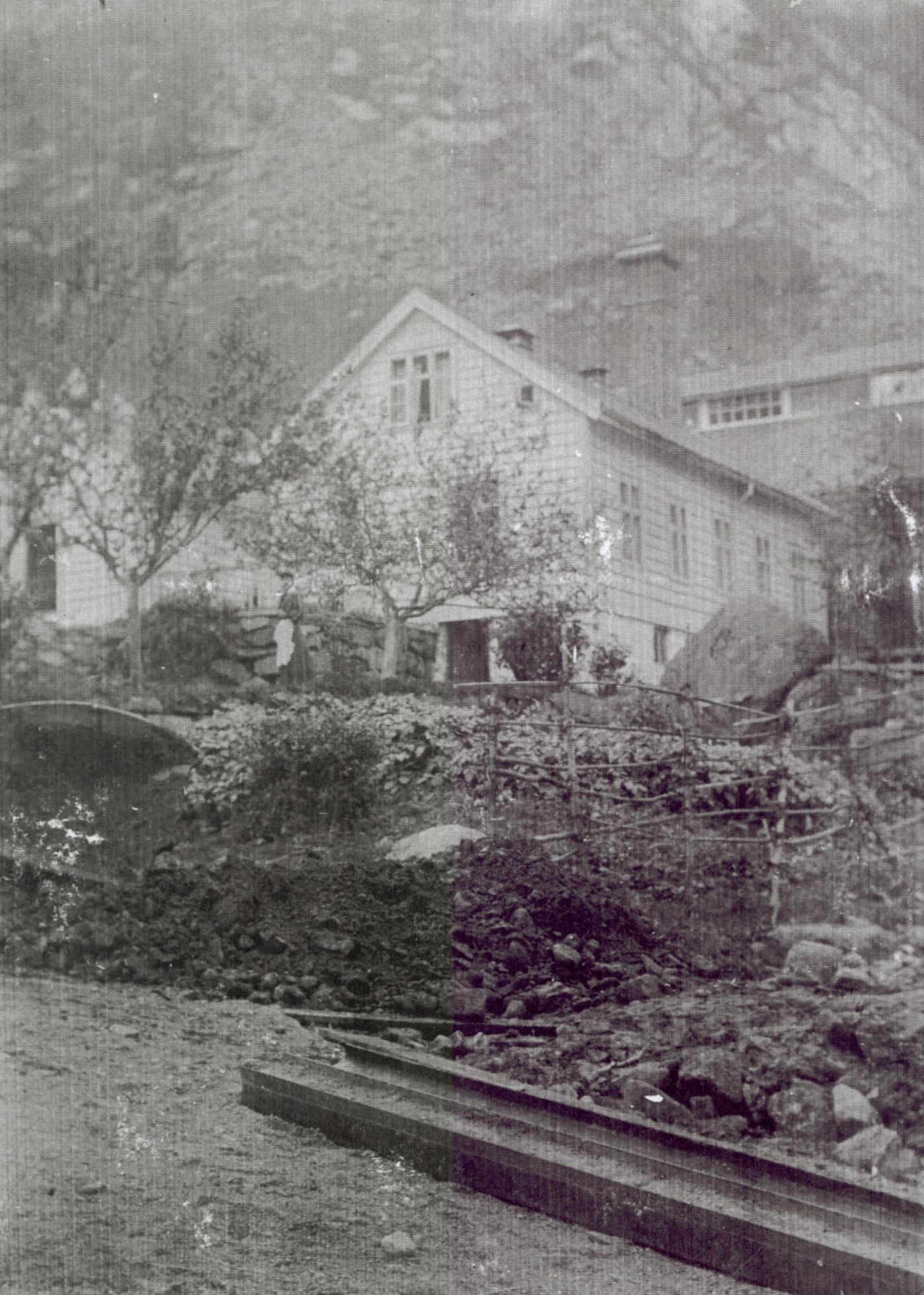 Gamal og ny tid møtest. Vi ser den staselege frukthagen bli rasert. Vi ser også restar av ei hes frå tida då husmennene skrapa saman for til geitene sine. I framgrunnen ei sluskebåre,  kalla geit. Basen sine ord når kvila var slutt: Lat geita trille!! Vi ser også eit par stålbjelkar,  tydelegvis kjøpt brukte.